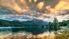 Vibrant Intense Sunset Landscape On Lake And Mountain Background