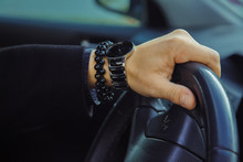 Color Image Of Adult Male Hand With Watch And Bracelet In Car