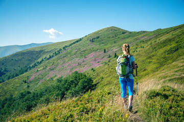 Wall Mural - young woman hiking in the mountains