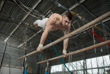 Athlete Topless Doing Exercises On The Uneven Bars