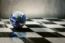 World Earth On A Chessboard Isolated On Grey Wall Background
