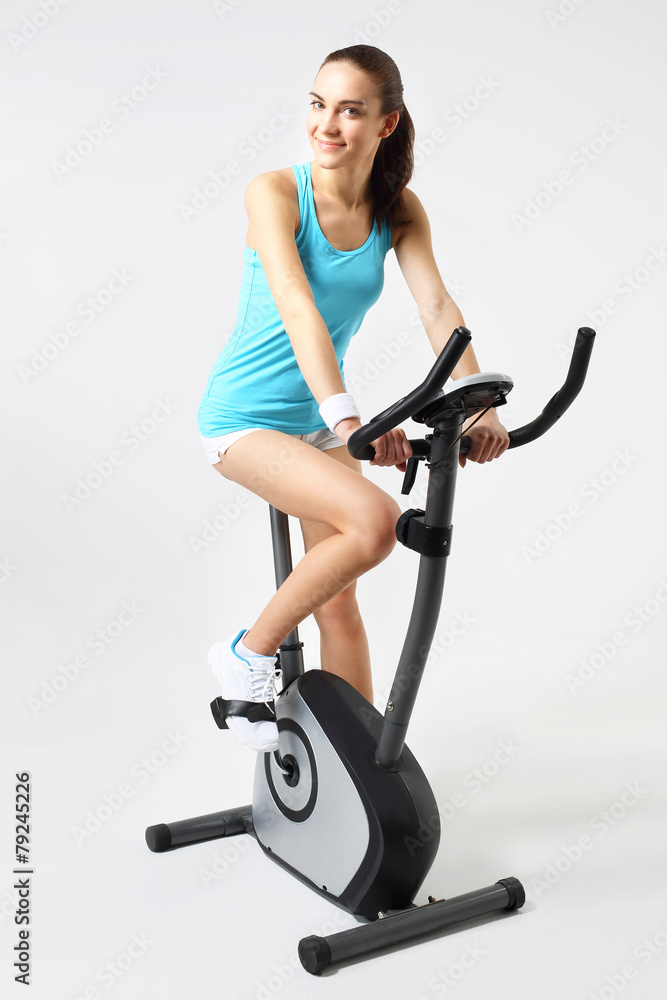 Spinning, kobieta ćwiczy na rowerze stacjonarnym - obrazy, fototapety, plakaty 