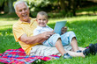 © .shock - grandfather and child in park using tablet