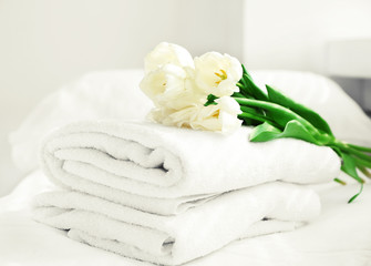 Wall Mural - White beautiful tulips on fresh towels in hotel, close up