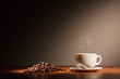 Coffee cup with steam and coffee beans