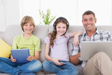 Sticker - Happy man with children using technologies on sofa