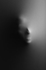 Canvas Print - Human face pressing through fabric as horror background