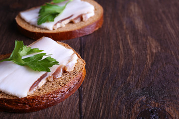 Wall Mural - Sandwiches with lard and parsley on wooden background