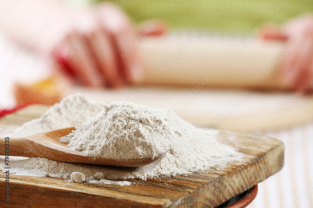 Young woman prepares dough on table close up