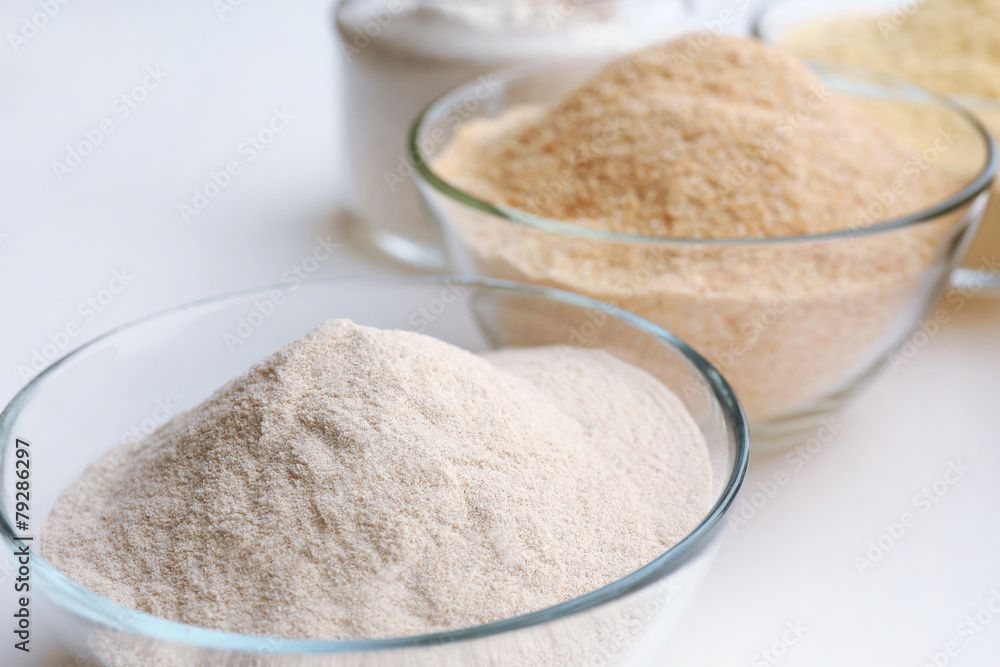 Different types of flour in bowls close up