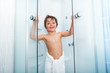 © Sergey Novikov - Happy boy getting out of shower covered in towel
