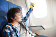 © Sergey Novikov - Little smiling boy with toy plane by the window