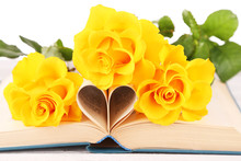 Open Book With Shape Of Heart From Pages And Yellow Roses