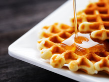 Honey pouring on a fresh waffles