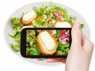 Poster - tourist taking photo of green salad with cheese