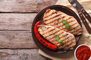 Wall Mural - Grilled chicken fillet and chili on a plate horizontal top view