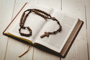 open bible and wooden rosary beads