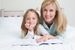 © WavebreakMediaMicro - Happy mother and daughter reading a book