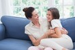 © WavebreakMediaMicro - Mother and daughter laughing on couch