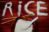 Fototapeta  - Rice on wooden table with chopsticks