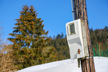 electric meter on an old post on blue sky background