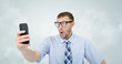 © afxhome - Funny businessman photographing himself on a smartphone