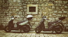 Two Mopeds In Front Of The Wall