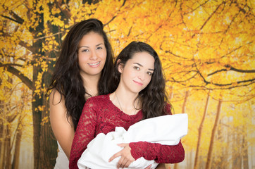 Wall Mural - portrait of beautiful lesbian couple holding their baby