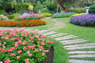 Brown chair in a flowers garden with walkway