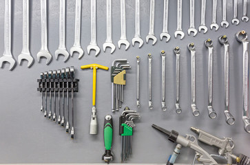 Spanners hanging on grey wall