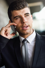 Wall Mural - Young businessman on the phone in an office building