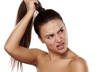 Wall Mural - nervous young woman holding her ponytail