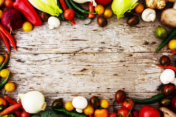 Frame of various vegetables over a rustic wooden background with