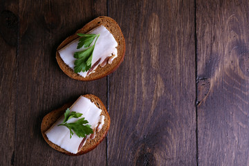 Wall Mural - Sandwiches with lard and parsley on wooden background