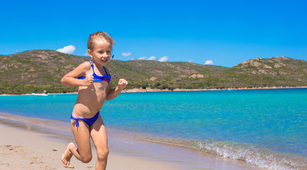 Adorable little girl have fun on tropical white sandy beach