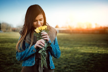 Attractive Young Woman With Yellow Rose In The Park