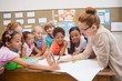 © WavebreakmediaMicro - Teacher and pupils working at desk together