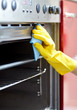 © Syda Productions - close up of woman cleaning oven at home kitchen