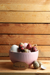 Wall Mural - Bird colorful eggs in bowl on wooden background