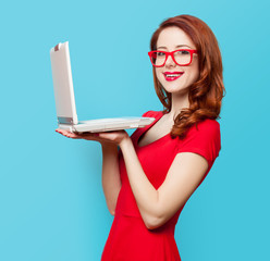 Wall Mural - Smiling redhead girl with laptop