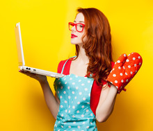 Young Housewife With Computer And Oven Gloves