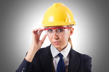 Young businesswoman with hard hat on white