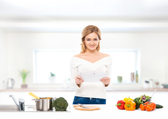 Young and beautiful housewife woman cooking in the kitchen