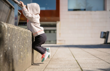 Wall Mural - Little girl with sneakers and hoodie training outdoors
