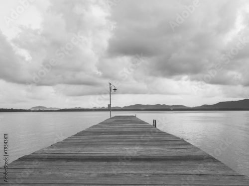 Fototapeta na wymiar Pier with sea and Cloudy sky black and white