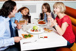 © stockyimages - Family eating together in hotel.