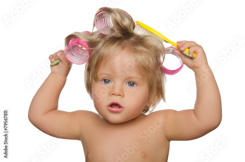 Naklejka na drzwi Little beautiful girl with hair curlers and comb