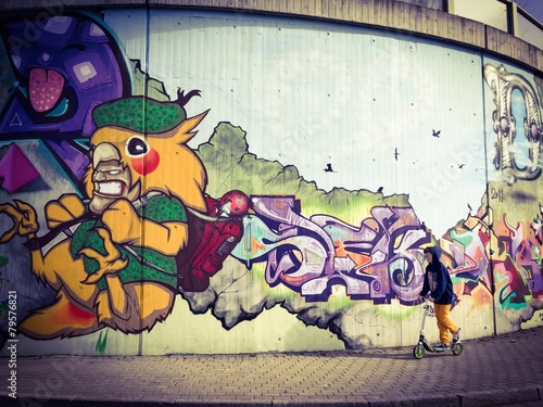 chlopiec-jedzie-hulajnoga-przy-graffiti-sciana