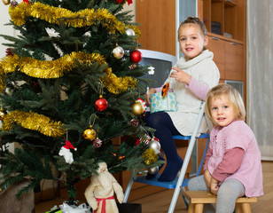 Wall Mural - Little girls decorating Christmas tree