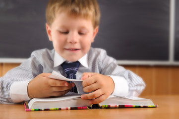 Canvas Print - Cute boy with books at the desk